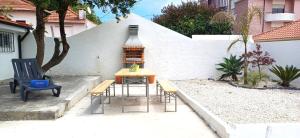 a patio with a table and chairs and a lamp at 1000Jo Apartment T2 in Gulpilhares