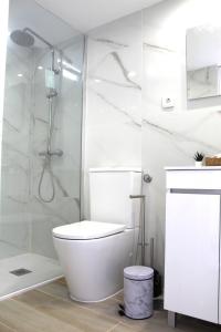 a white bathroom with a toilet and a shower at 1000Jo Apartment T2 in Gulpilhares +7 photos