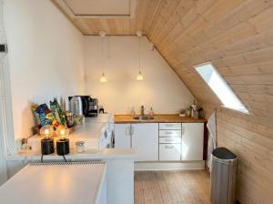a kitchen with white appliances and a wooden ceiling at Penthouse - 3BR - Esbjerg Island in Esbjerg