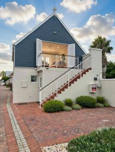 a house with a blue roof and a staircase at Luxurious Loft on Spinnaker! in Knysna