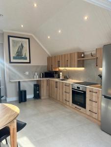 a large kitchen with wooden cabinets and a table at Luxurious Loft on Spinnaker! in Knysna