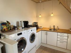 a kitchen with a washing machine and a sink at Penthouse - 3BR - Esbjerg Island in Esbjerg +14 photos