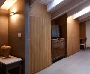 a waiting room with a tv and a dresser with a tv gmaxwell gmaxwell gmaxwell at B&B Sottotetto in Reggio Emilia