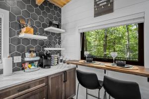 a kitchen with a counter with chairs and a window at NEW - Treehouse - Dogwood in Jonesburg