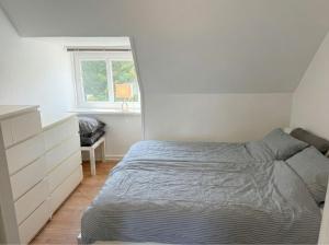 a bedroom with a bed and a dresser and a window at Penthouse - 3BR - Esbjerg Island in Esbjerg