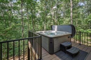 a hot tub on a deck with trees at NEW - Treehouse - Dogwood in Jonesburg +1 photo