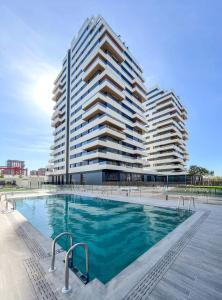 a large building with a swimming pool in front of a building at SingularStays Arena in Valencia