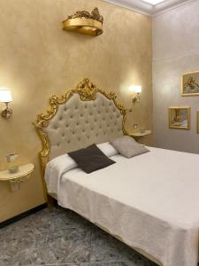 a bedroom with a large bed with a gold frame at Suite Incentro Salerno in Salerno