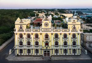 a large yellow building on top of a city at SK Grand Palace in Pondicherry
