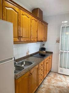 a kitchen with wooden cabinets and a sink at Angeleyes in San Pedro del Pinatar
