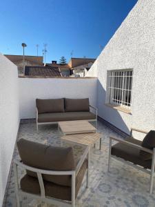 a patio with couches and tables on a building at Angeleyes in San Pedro del Pinatar
