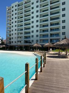 a resort with a boardwalk and a large building at Fantástico Depa en BLUU con Playa Artificial ! in Mazatlán