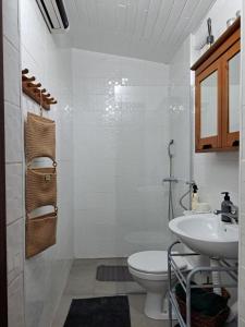 a white bathroom with a sink and a toilet at Piknik Garden in Senta
