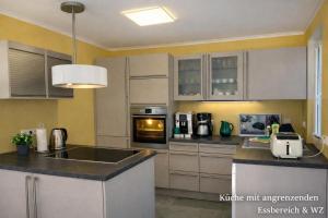 a kitchen with a sink and a stove top oven at Villa Mara - für 12 Gäste, Sauna, 1 Wirlwanne, 2 Duschen, Kamin, 5 SZ, 3 WC, Highspeed Internet, abgezeuntes Grundstück in Glowe