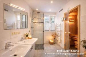 a bathroom with two sinks and a shower at Villa Mara - für 12 Gäste, Sauna, 1 Wirlwanne, 2 Duschen, Kamin, 5 SZ, 3 WC, Highspeed Internet, abgezeuntes Grundstück in Glowe