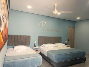 two beds in a room with a sign on the wall at Panorama 1947 - Hotel Boutique Galería in El Banco +40 photos