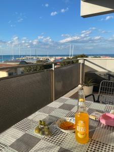 a bottle of beer sitting on a table on a balcony at Blue Zen beachfront apartment in Civitanova Marche