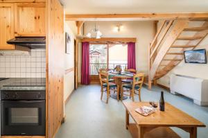 a kitchen and dining room with a table and chairs at Alpes Roc in Pralognan-la-Vanoise