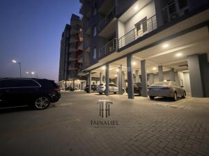 a parking lot with cars parked in front of a building at Tainaliel Homes and Properties in Mama