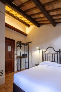 a bedroom with a white bed and a wooden ceiling at Casa Delicato - B&B - Camere - Ospitalità in Contigliano