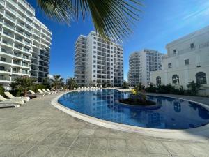 a large swimming pool in the middle of some buildings at Caesar Resort Atilius in Trikomo