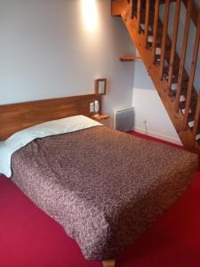 a bedroom with a bed and a staircase at Le Motel Saint Martin in Verneuil d'Avre et d'Iton
