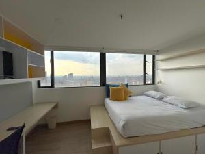 a bedroom with a large bed with a large window at Happa Hub Hotel in Bogotá +74 photos