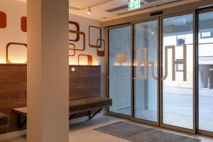 a room with sliding glass doors and a bench at HUB Apartments St Georg in Hamburg