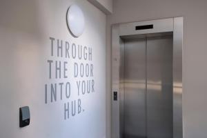 a door into a hallway with a sign on the wall at HUB Apartments St Georg in Hamburg