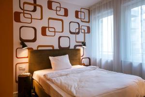 a bedroom with a bed and a wall with mirrors at HUB Apartments St Georg in Hamburg