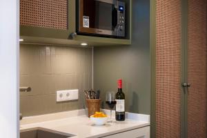 a kitchen with a counter with a bottle of wine at HUB Apartments St Georg in Hamburg +64 photos