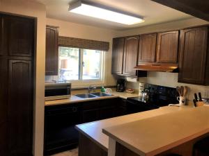 a kitchen with wooden cabinets and a sink and a window at Mammoth Creek Unit 15 in Mammoth Lakes +6 photos
