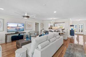 a living room with a white couch and a table at Harbor On Holiday Isle in Destin +32 photos