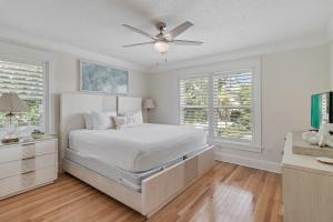 a white bedroom with a bed and a ceiling fan at Harbor On Holiday Isle in Destin