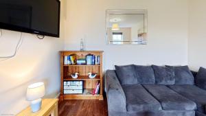a living room with a couch and a tv at Coral Shores - Part of the The Bay Filey Holiday Village with pool, gym and direct beach access, pub, restaurant, tennis and meadows walks in Filey