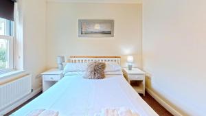 a white bedroom with a bed and a window at Coral Shores - Part of the The Bay Filey Holiday Village with pool, gym and direct beach access, pub, restaurant, tennis and meadows walks in Filey +39 photos