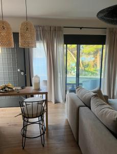 a living room with a couch and a table at KLA Luxury Boutique Villa with Pool & Jacuzzi by WESTBOOKING GR in Nikiana