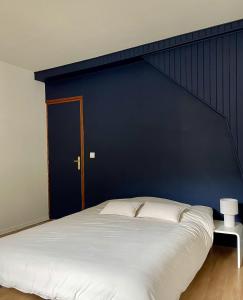 a bedroom with a large bed with a blue wall at Chez Joséphine et Pierre in Cassel