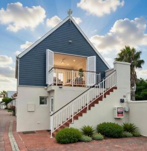 a house with a blue roof and stairs at Luxurious Loft on Spinnaker! in Knysna +5 photos