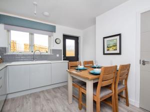a kitchen with a table and chairs and a sink at Oakwood in Aviemore