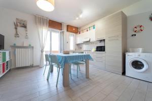 a kitchen with a table and chairs in a kitchen at AZZURRO LIDO ADRIANO VISTA MARE in Lido Adriano