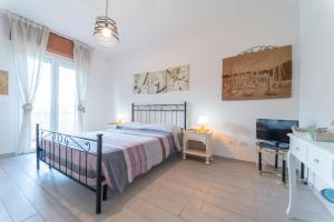 a bedroom with a bed and a flat screen tv at AZZURRO LIDO ADRIANO VISTA MARE in Lido Adriano