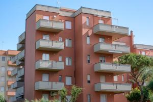 a red building with balconies on the side of it at AZZURRO LIDO ADRIANO VISTA MARE in Lido Adriano