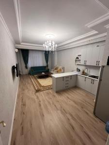 a kitchen with white cabinets and a living room at Caspian Mirvari in Sumqayıt