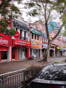 a street in a town with shops and a tree at Ayla Hostel at MITC in Ayer Keroh