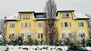 a yellow house with snow in front of it at Gästezimmer Traisen in Traisen