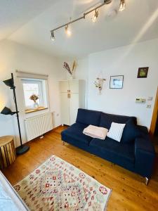 a living room with a blue couch and a rug at Gästezimmer Traisen in Traisen +2 photos