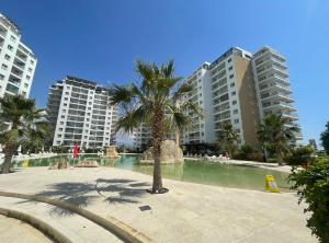a palm tree in a pool in front of buildings at Caesar Resort Atilius in Trikomo