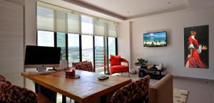 ein Zimmer mit Schreibtisch, Computer und Stühlen in der Unterkunft Lujoso Dpto vista a ciudad Edificio Poseidón in Manta