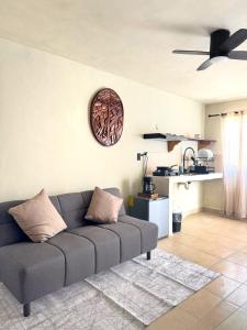 a living room with a couch and a clock on the wall at Casa Roca II in Isla Mujeres